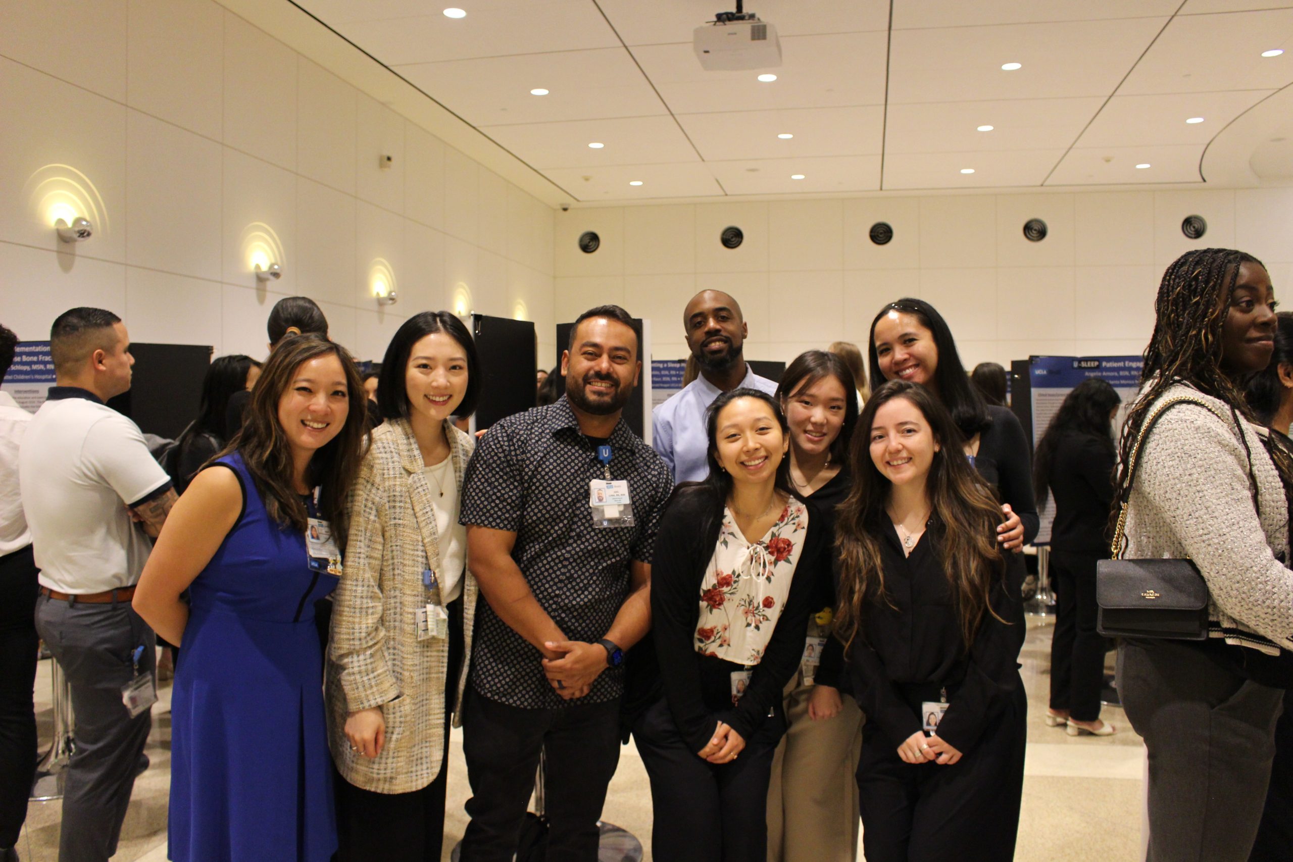 A group of smiling professionals pose together at an indoor event.